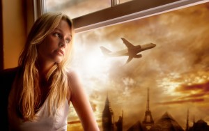 Девушка смотрит в окно на улетающий самолёт
