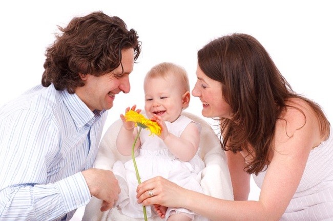 Родители с маленьким ребёнком и цветком